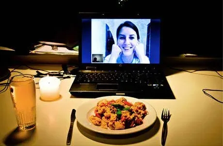 Virtual dinner date with meal and candle on video call